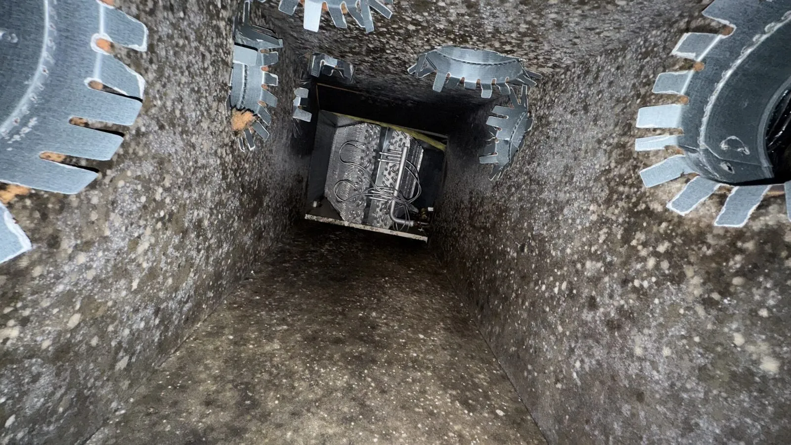 Supply plenum from above: dust on the walls, takeoff collars visible