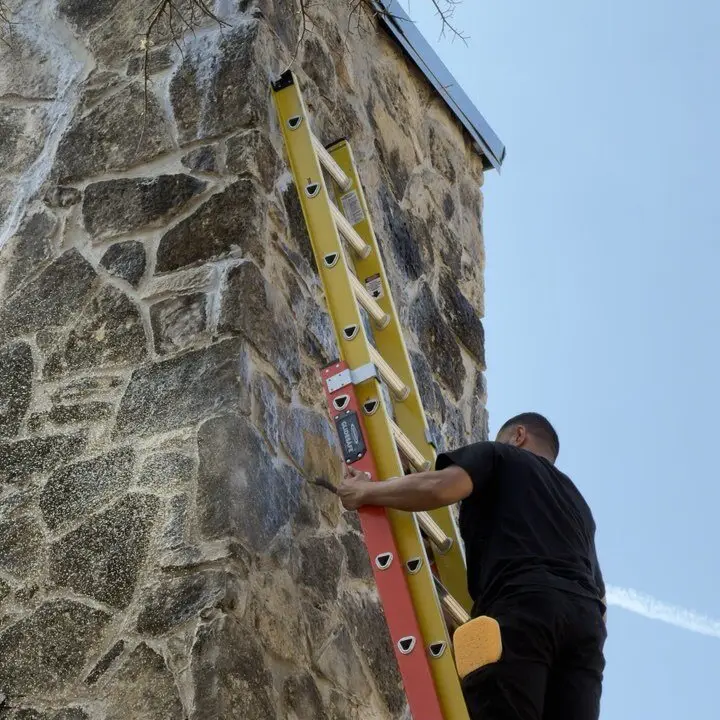 Repointing the chimney from a ladder, Central Texas